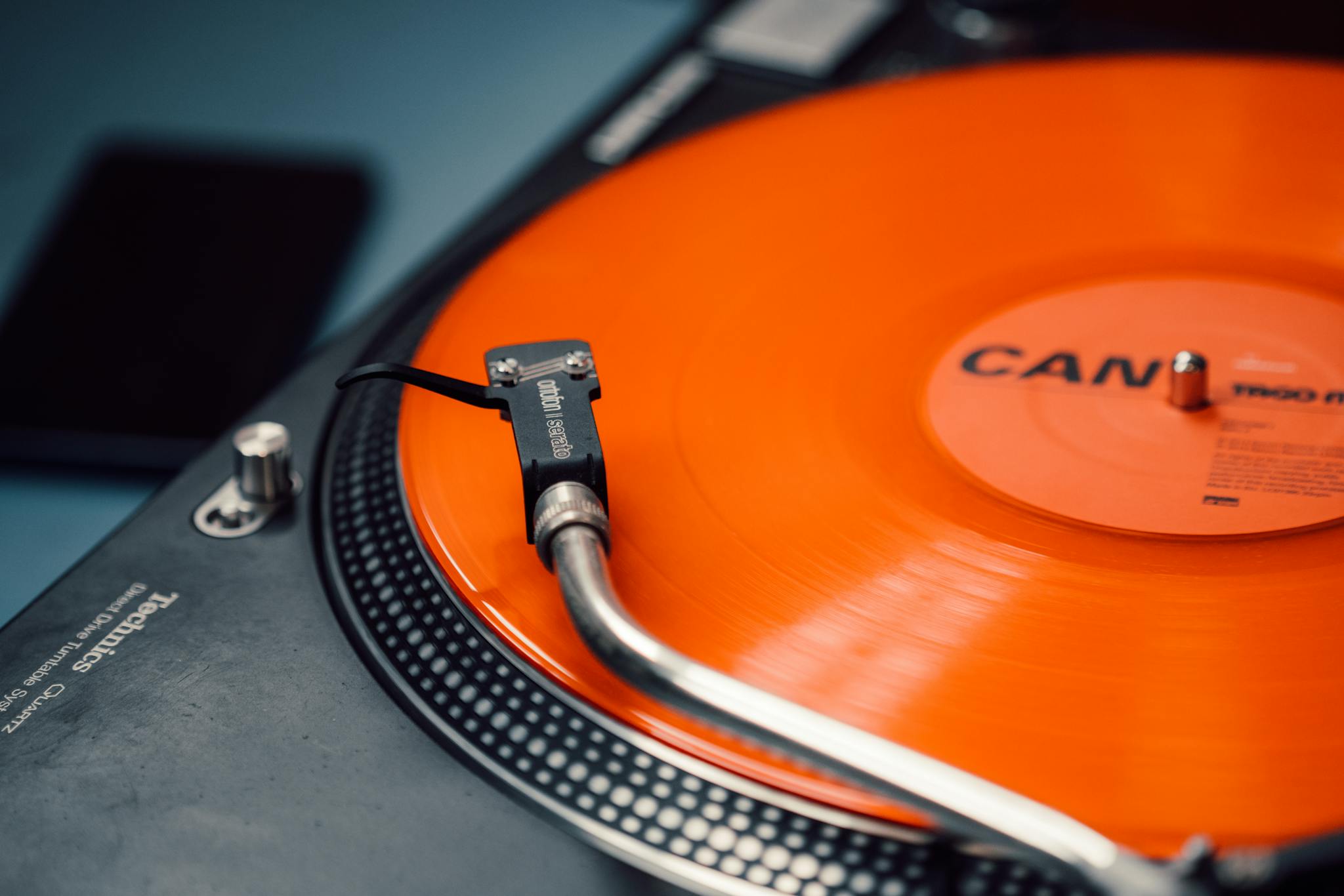 Close-up of a spinning orange vinyl record on a classic turntable.